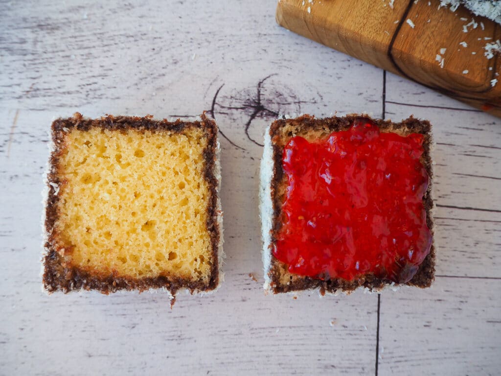 Cut open lamington with jam on one side