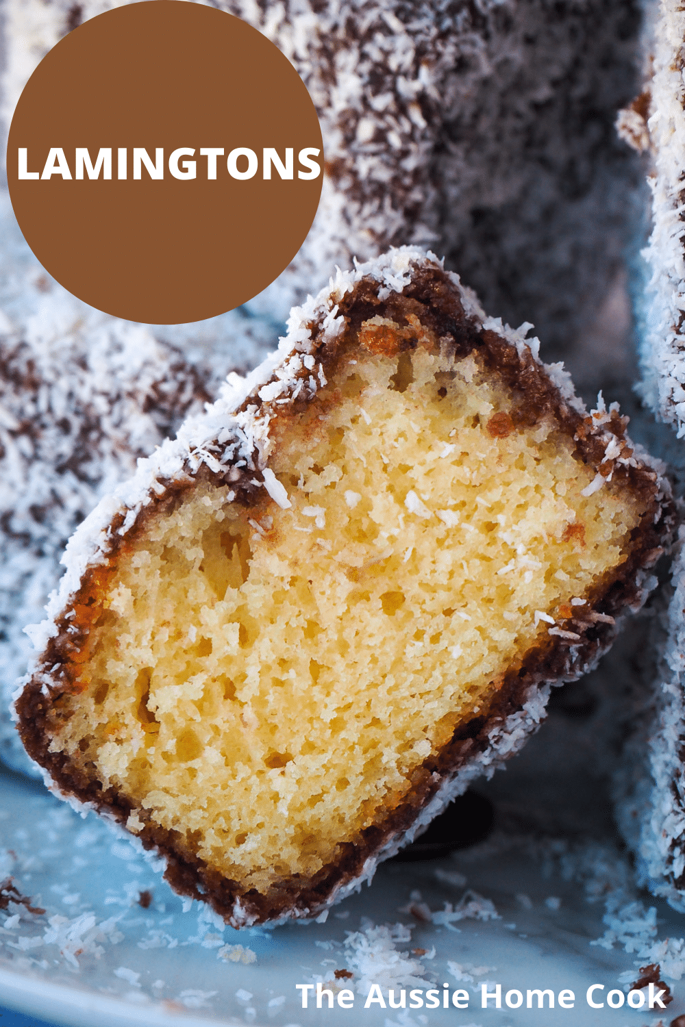 Close up of cut open lamington with other lamingtons piled around it, and text overlay, Lamingtons, the Aussie home cook.