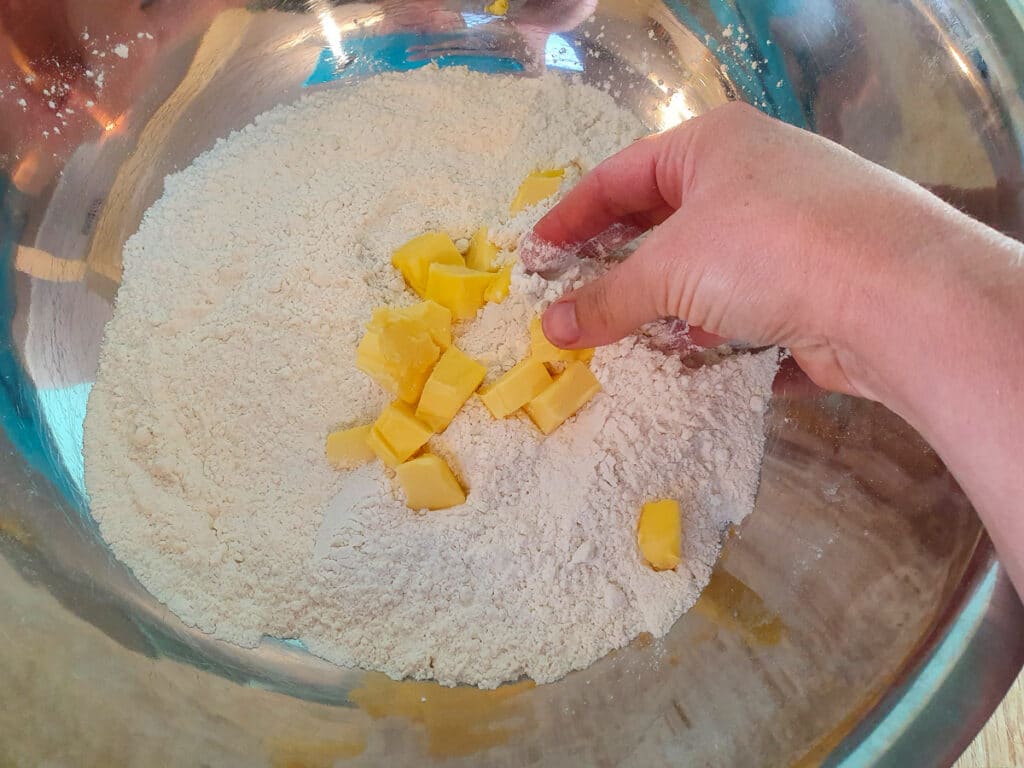 Rubbing butter into the flour.